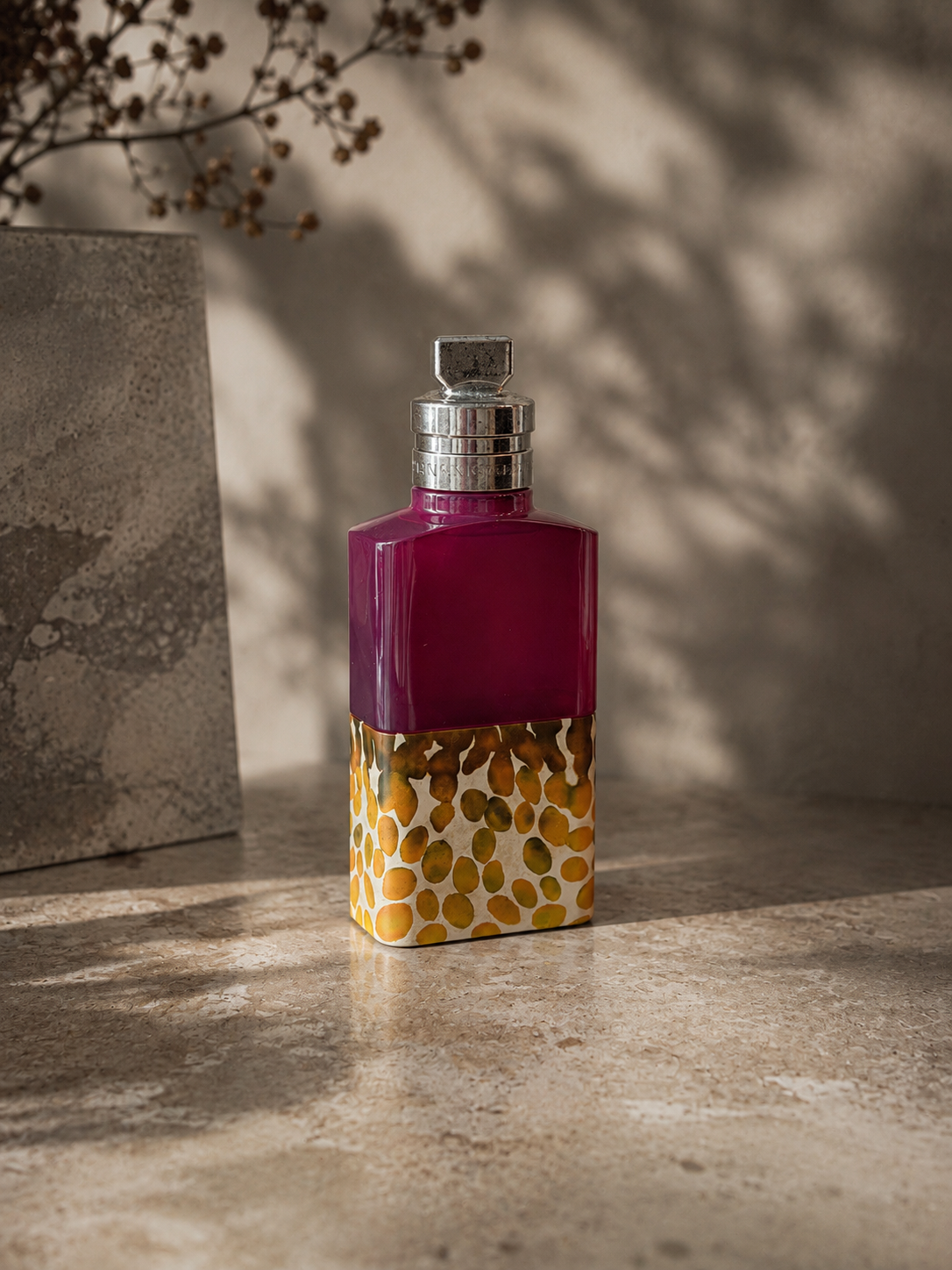 Dries Van Noten Velvet Violet bottle on a stone surface in soft shadow